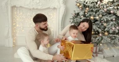 Neşeli genç ebeveynler ve sevimli küçük oğullar Noel 'i kutluyor ve eğleniyorlar. Aile tatilleri. Çocukluk kavramı.