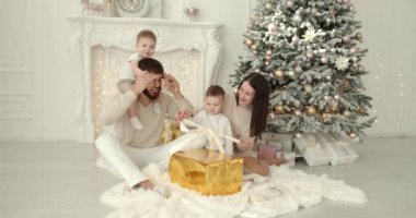 Neşeli genç ebeveynler ve sevimli küçük oğullar Noel 'i kutluyor ve eğleniyorlar. Aile tatilleri. Çocukluk kavramı.