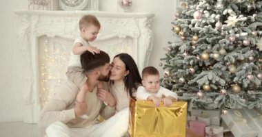 Neşeli genç ebeveynler ve sevimli küçük oğullar Noel 'i kutluyor ve eğleniyorlar. Aile tatilleri. Çocukluk kavramı.