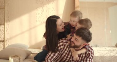Noel 'de iki çocuklu mutlu bir aile yatakta yan yana yatıyor. Neşeli genç ebeveynler ve sevimli küçük oğullar Noel 'i yatak odasında kutluyorlar..