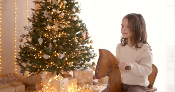 Una Chica Montada Caballo Madera Juguete Cerca Del Árbol Navidad — Vídeos de Stock