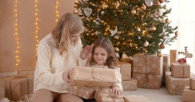 Vay canına. Noel arifesinde güzel bir kız ve anne köknar ağacının yanında oturuyor. Etraflarında hediyeler, hediyeleri açıyorlar..