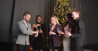 Yakın arkadaşlar Xmas 'la tanışır ve ellerinde şampanya içerler. Noel, arkadaşlık, tatil, yaşam tarzı, reklam, ticari konsept. 4K 'da yakın çekim..