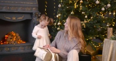 Anne ve kızı Noel hediyelerini açıyor. Noel 'i kutluyoruz, aile zamanı..