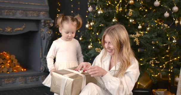 母と娘はクリスマスの贈り物をアンパックします クリスマスを祝う家族の時間 — ストック動画