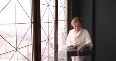 Noel kutlaması. Olgun bir kadın Noel hediyesini açıyor. Evde kal, uzak tatil, duygusal ev hayatı..