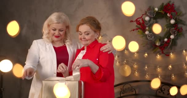 Весела Старша Жінка Відкриває Коробку Подарунками Святкування Крістмазенської Дочки Вдома — стокове відео
