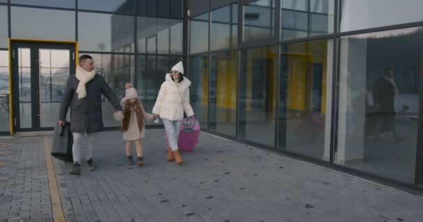 Młoda Rodzina Córką Bagażem Opuszcza Lotnisko Zimowy Weekend Rodzinny Koncepcja — Wideo stockowe