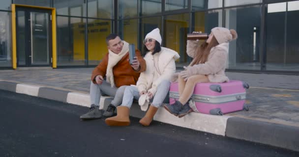 Młoda Rodzina Ubrana Zimowe Ubrania Uroczą Córką Siedzącą Walizkach Przed — Wideo stockowe