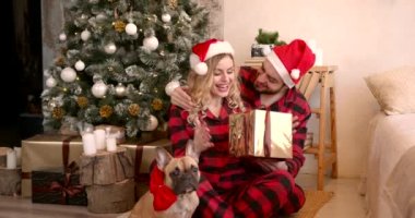Mutlu gençlerin Noel sabahı buluşması. Komik Noel Baba şapkaları giyiyorlar ve hediye kutularını değiş tokuş ediyorlar..