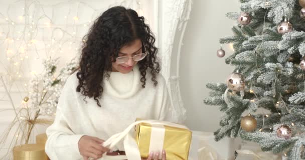 Жінка Светрі Розпаковує Подарунок Новий Рік Від Санти Клауса Сидячи — стокове відео