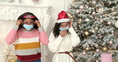 Noel tatili için hazırlık. Kızlar koruyucu maske takıyor. Karantina, Coved-19 konsepti.