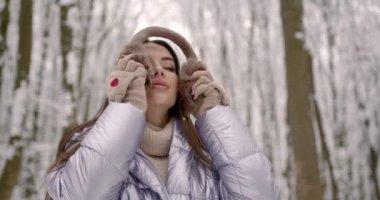 Kadın kürk etkilidirler onun başının üstüne koy. Kış ormandaki karlı köknar ağaçları ile güzel manzara.