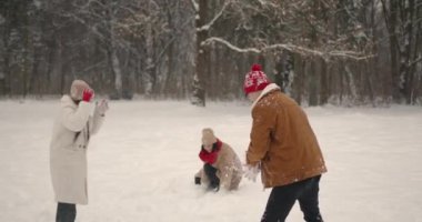 Anne ve ergen çocukları güzel kış ormanlarında koşuyorlar. Birlikte vakit geçiriyoruz, güzel bir aileyiz. Noel tatili.
