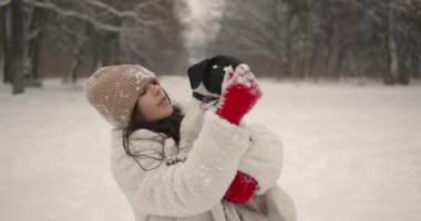 Kış tatili Parkta ya da ormanda köpek yavrusuyla yürüyüşe çıkan genç bir kadın. Hafta sonu dışarıda. Evcil hayvanlar.