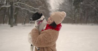 Kış tatili Parkta ya da ormanda köpek yavrusuyla yürüyüşe çıkan genç bir kadın. Hafta sonu dışarıda. Evcil hayvanlar.