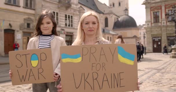 母亲带着她的小女儿站在横幅上 用文字制止战争 为乌克兰祈祷 — 图库视频影像