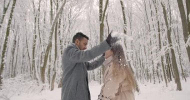 İyi tatiller. Romantik genç çift. Karlı kış günü. Noel ve tatil kavramı - mutlu çift kış ormanlarında eğleniyor..