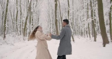 İyi tatiller. Romantik genç çift. Karlı kış günü. Noel ve tatil kavramı - mutlu çift kış ormanlarında eğleniyor..