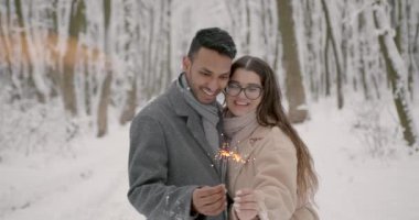 Kış ormanında gülümseyen maytaplı bir çift. Kış doğasında bir çift. Kutlayan çift.