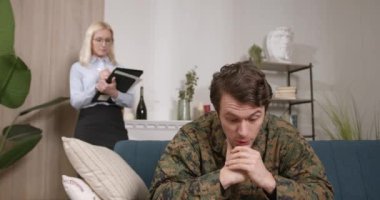 Askeri üniformalı sıkıntılı genç adam terapi sırasında psikologla konuşuyor, içeride. Yardım, destek, travma sonrası stres bozukluğu, sağlık ve uyum kavramı.