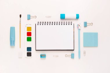 Okul gereçleri ve kırtasiye malzemeleriyle dolu modern beyaz ofis masaüstünün en üst görüntüsü mesaj için boş alan etrafında. Okula dönüş konsepti dairesi modelle yatıyordu.