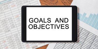 Masaüstünüzde metin Hedefleri ve Hedefleri olan belgeler, raporlar ve grafiklerle tablet. İş ve finans kavramı