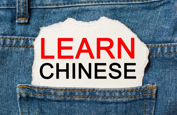 Learn Chinese on torn paper background on jeans study and education concept