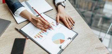 İş kadını çizelgeleri kontrol eder ve mali ilerlemeyi tazeler. Kız iş yerindeki iş modelini analiz ediyor..