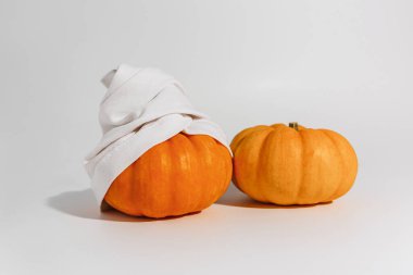 Beyaz arka planda yüz maskesi ve havlusu olan balkabağı. Metin modelleme kaplıcası ve Cadılar Bayramı konsepti için yer