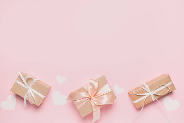 Gifts with wihte ribbon on isolated pink background, love and valentine concept