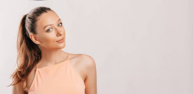 Gülümseyen ve poz veren güzel bir genç kız beyaz izole bir arka planda kameraya bakıyor. Pozitif esmer kadın. Nazik bak. Güzel surat..