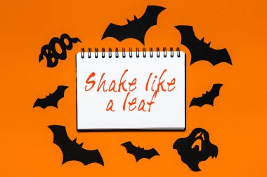 Cadılar bayramı konseptin kutlu olsun. Yazılı not: Beyaz ve turuncu arka planda yarasalar, balkabakları ve hayaletlerle sallanan bir yaprak gibi