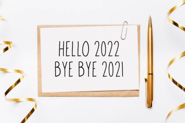 Merhaba 2022. Güle güle 2021. Zarf, hediyeler ve beyaz arka planda altın kurdele.
