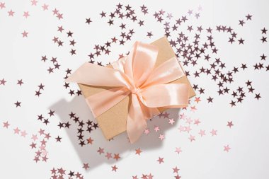 Beyaz arka planda mor yıldız şeklinde parıldayan bir hediye. Tatil, doğum günü, düğün, yeni yıl, Noel, parti, kutlama konsepti