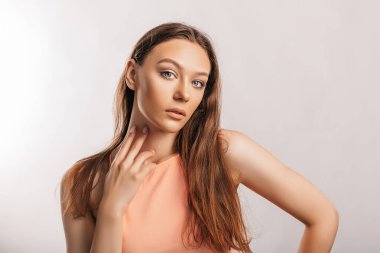 Gülümseyen ve poz veren güzel bir genç kız beyaz izole bir arka planda kameraya bakıyor. Pozitif esmer kadın. Nazik bak. Güzel surat..