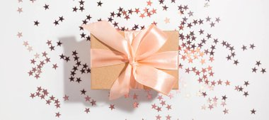 Beyaz arka planda mor yıldız şeklinde parıldayan bir hediye. Tatil, doğum günü, düğün, yeni yıl, Noel, parti, kutlama konsepti