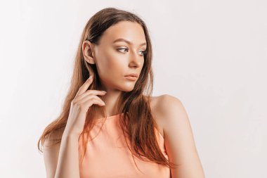 Gülümseyen ve poz veren güzel bir genç kız beyaz izole bir arka planda kameraya bakıyor. Pozitif esmer kadın. Nazik bak. Güzel surat..