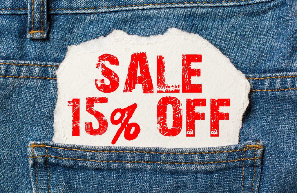 Sale 15 off on white paper in the pocket of blue denim jeans
