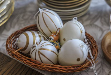 Paskalya masasında yumurtaların arasına gizlenmiş bir tavşan.