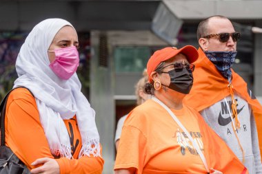 İnsanlar, Toronto, Ontario 'daki Dundas Meydanı' nda düzenlenen Turuncu Gömlek Günü ve Ulusal Gerçek ve Uzlaşma Günü 'ne iyileşmek, halkı bilinçlendirmek ve yerli bir topluluk olarak birlikte yükselmek için katılıyor..