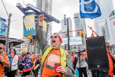 İnsanlar, Toronto, Ontario 'daki Dundas Meydanı' nda düzenlenen Turuncu Gömlek Günü ve Ulusal Gerçek ve Uzlaşma Günü 'ne iyileşmek, halkı bilinçlendirmek ve yerli bir topluluk olarak birlikte yükselmek için katılıyor..