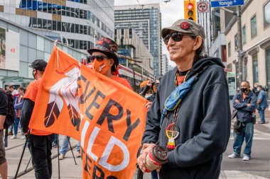İnsanlar, Toronto, Ontario 'daki Dundas Meydanı' nda düzenlenen Turuncu Gömlek Günü ve Ulusal Gerçek ve Uzlaşma Günü 'ne iyileşmek, halkı bilinçlendirmek ve yerli bir topluluk olarak birlikte yükselmek için katılıyor..