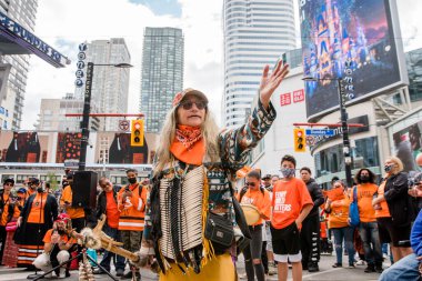 İnsanlar, Toronto, Ontario 'daki Dundas Meydanı' nda düzenlenen Turuncu Gömlek Günü ve Ulusal Gerçek ve Uzlaşma Günü 'ne iyileşmek, halkı bilinçlendirmek ve yerli bir topluluk olarak birlikte yükselmek için katılıyor..