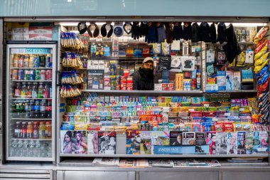 New York City, ABD - 22 Aralık 2021: New York 'ta Covid-19 salgını sırasında Daily Life. COVID-19 pandemik omikron dalgası sırasında Manhattan caddesindeki tezgahta dergi, çikolata ve diğer ürünler satan satıcı.