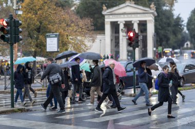 Roma, İtalya - 14 Kasım 2021: Şehirde insanlar kendilerini şemsiyelerle yağmurdan koruyorlar. Yağmurdaki vatandaşlar.
