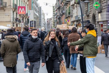 Napoli, İtalya - 24 Aralık 2021: Tarihi merkezin bir caddesinde yoğun bir kalabalık, covid-19 sağlık acil durumu nedeniyle koruyucu maskeler takarak yürüyor.