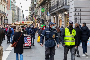 Napoli, İtalya - 24 Aralık 2021: Tarihi merkezin bir caddesinde yoğun bir kalabalık, covid-19 sağlık acil durumu nedeniyle koruyucu maskeler takarak yürüyor.