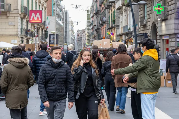 Napoli, İtalya - 24 Aralık 2021: Tarihi merkezin bir caddesinde yoğun bir kalabalık, covid-19 sağlık acil durumu nedeniyle koruyucu maskeler takarak yürüyor.