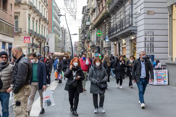 Napoli, İtalya - 24 Aralık 2021: Tarihi merkezin bir caddesinde yoğun bir kalabalık, covid-19 sağlık acil durumu nedeniyle koruyucu maskeler takarak yürüyor.